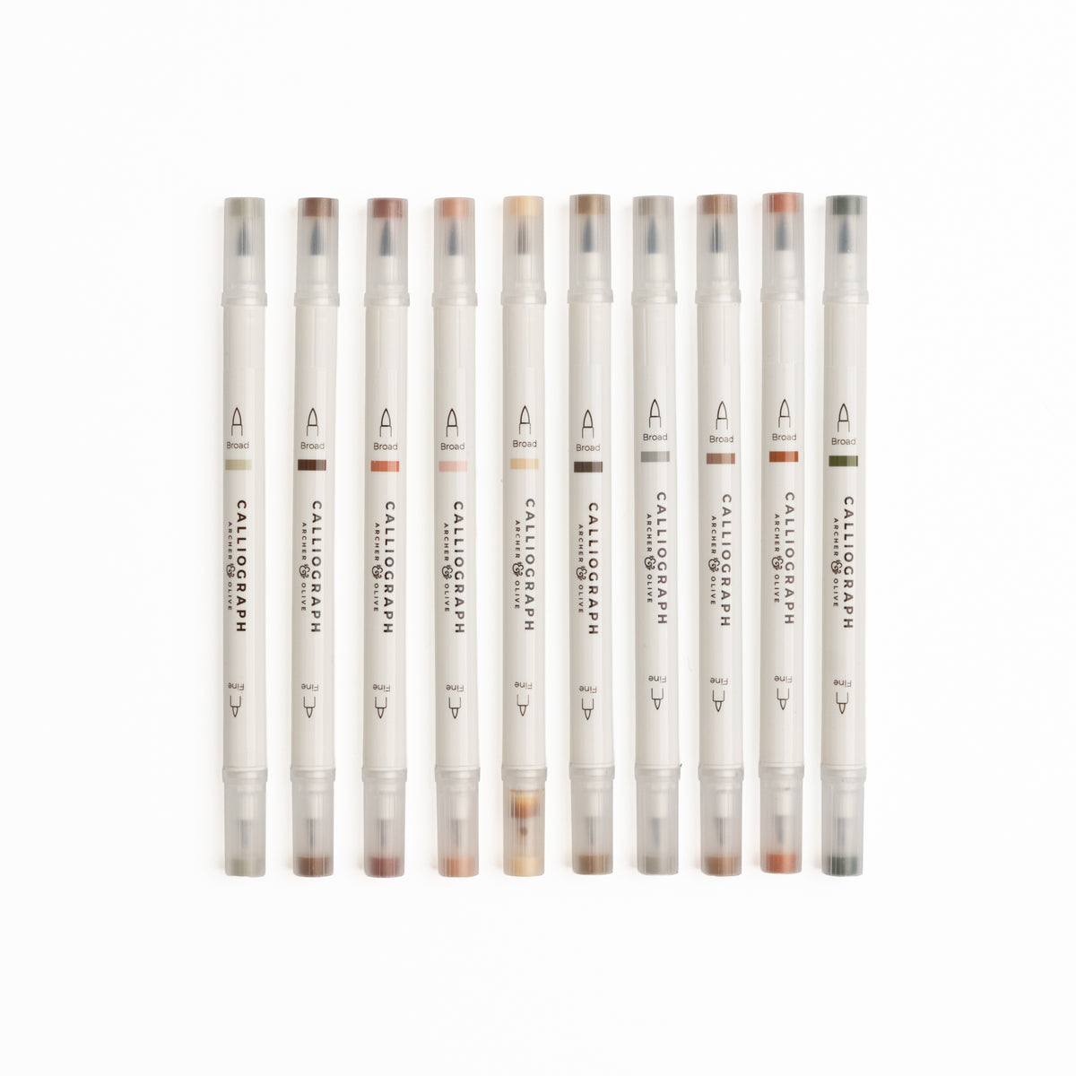 Set of ten Quiet Corners calligraphy pens with flexible brush tips laid out with lettering samples