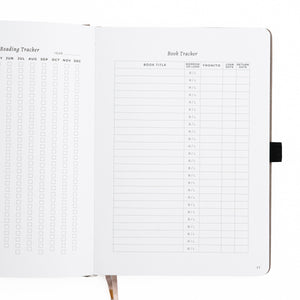 Notebook with reading and book tracker pages on a white background